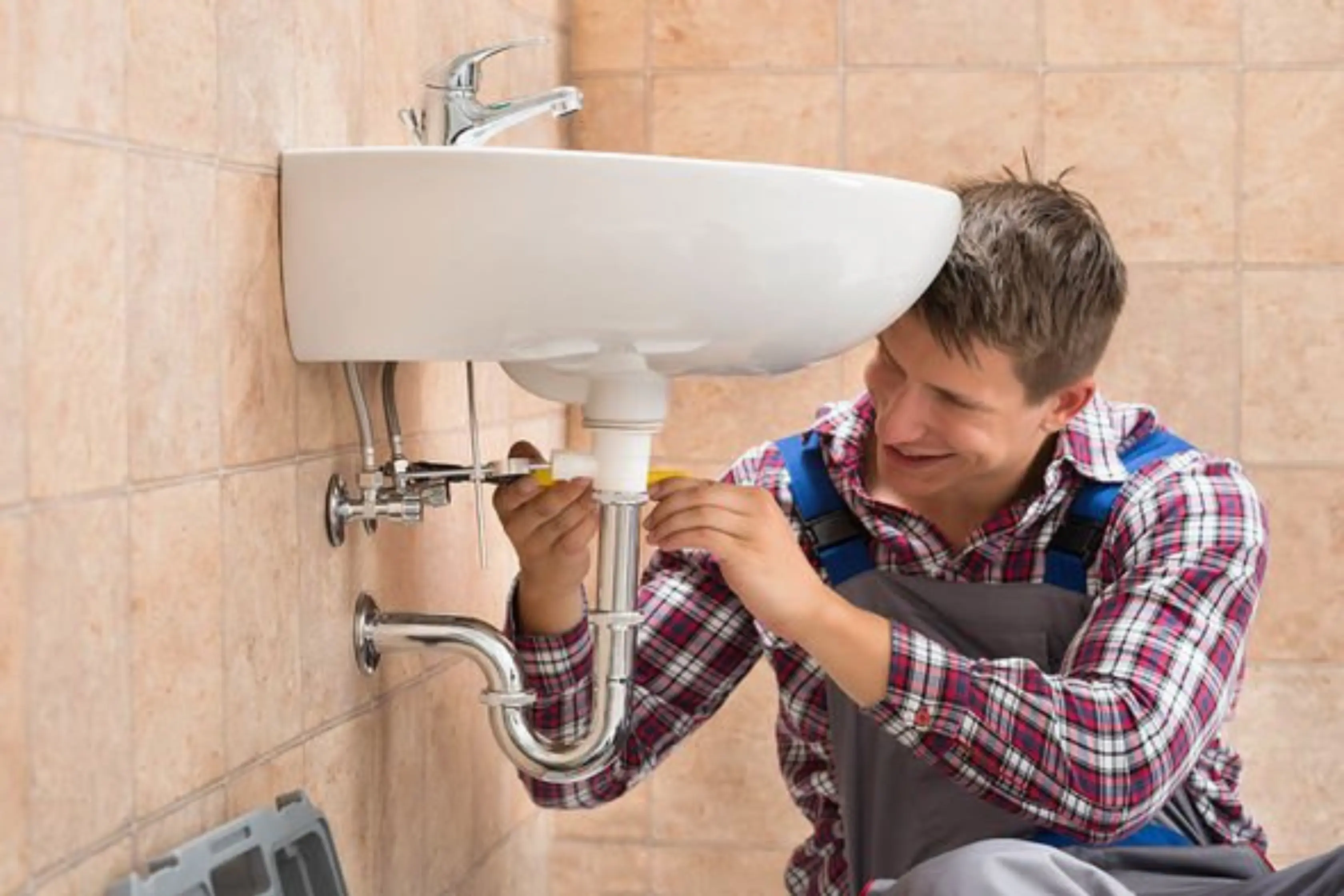 Plumber Fitting New Sink Into A Commercial Bathroom Space